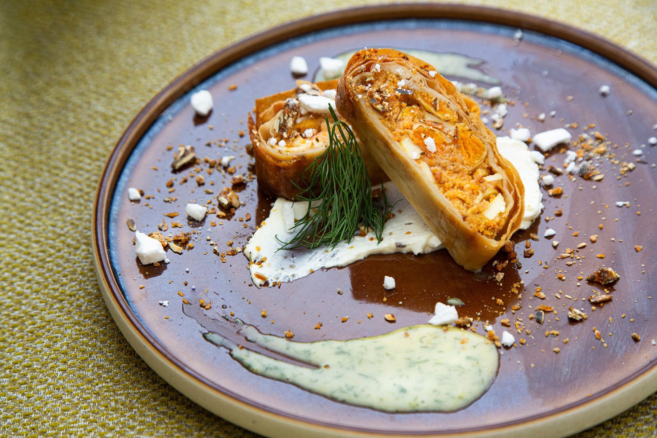 Steigenberger Hotel Herrenhof Відень Екстер'єр фото The photo shows a beautifully presented dish featuring what appears to be a rolled pastry, likely filled with a savory mixture. It is sliced to showcase the filling, which may include ingredients like vegetables, cheese, or meat. The plate is garnish