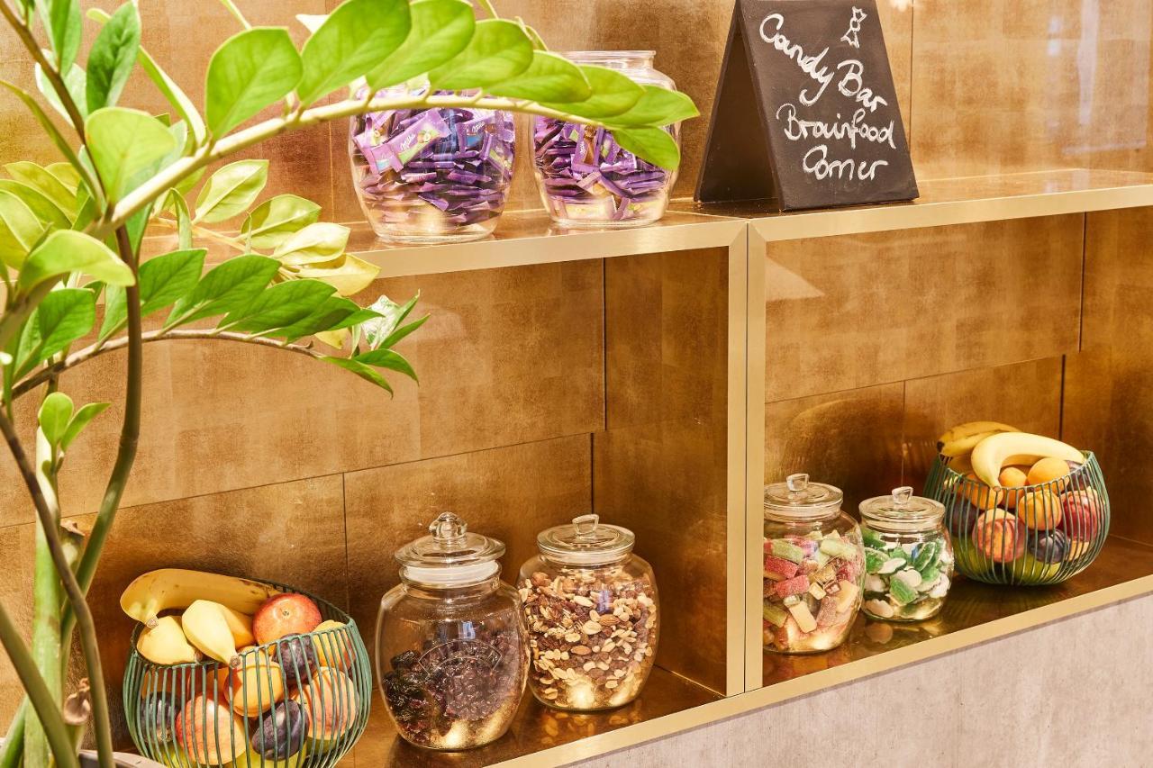 Steigenberger Hotel Herrenhof Відень Екстер'єр фото The photo features a display of food items in a neatly arranged setting. There are jars filled with various candies and snacks, indicated by a small chalkboard sign that reads "Candy Bar." Below this, there are jars containing a mix of dried fruits, 