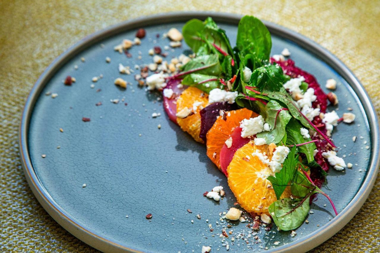 Steigenberger Hotel Herrenhof Відень Екстер'єр фото The photo shows a beautifully arranged plate of salad. It features vibrant slices of orange and a variety of greens, including spinach. There are also segments of beets, adding a pop of color. Crumbled white cheese is sprinkled on top, along with sma